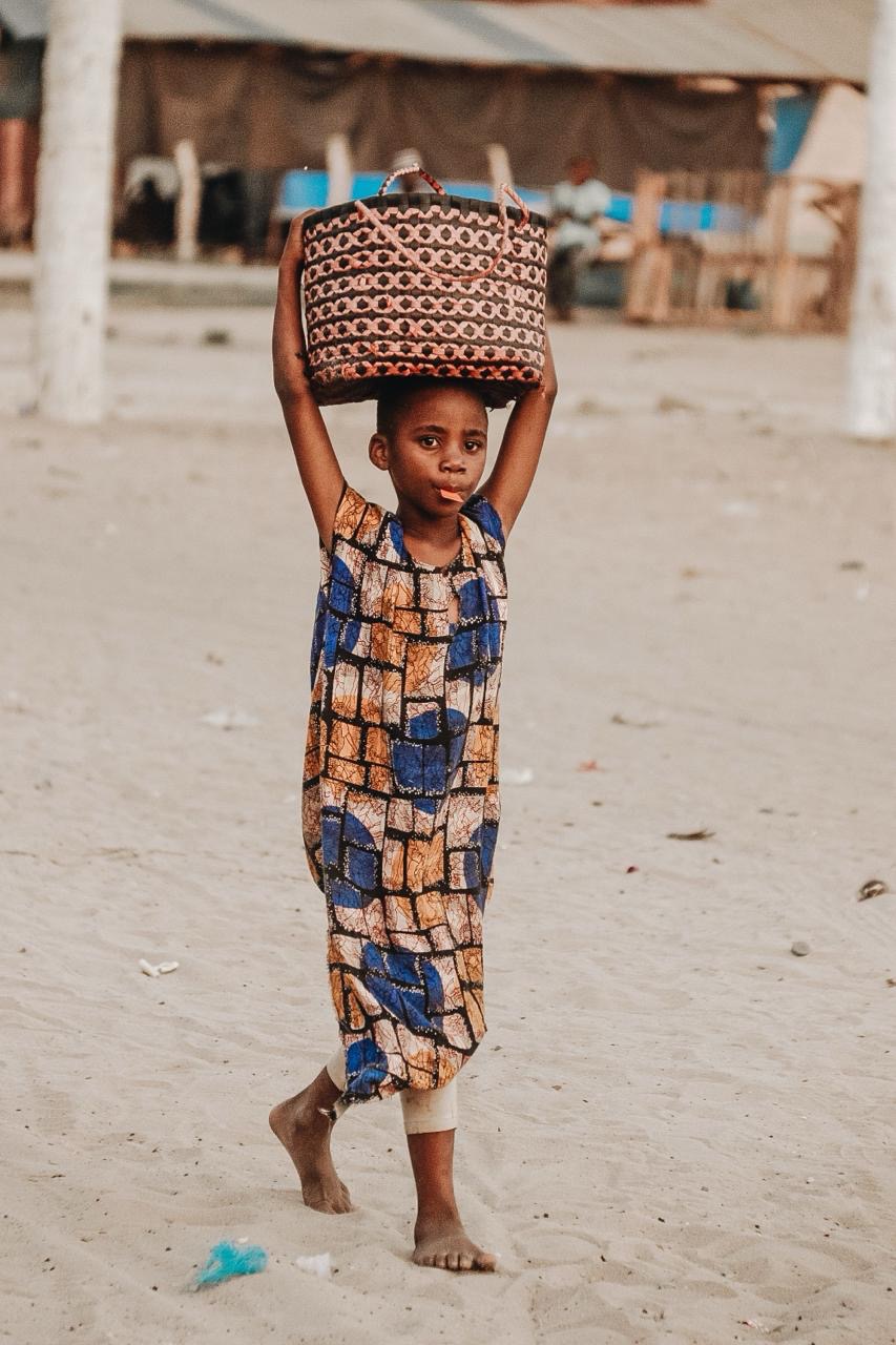 Young local resident carrying a basket in The Gambia